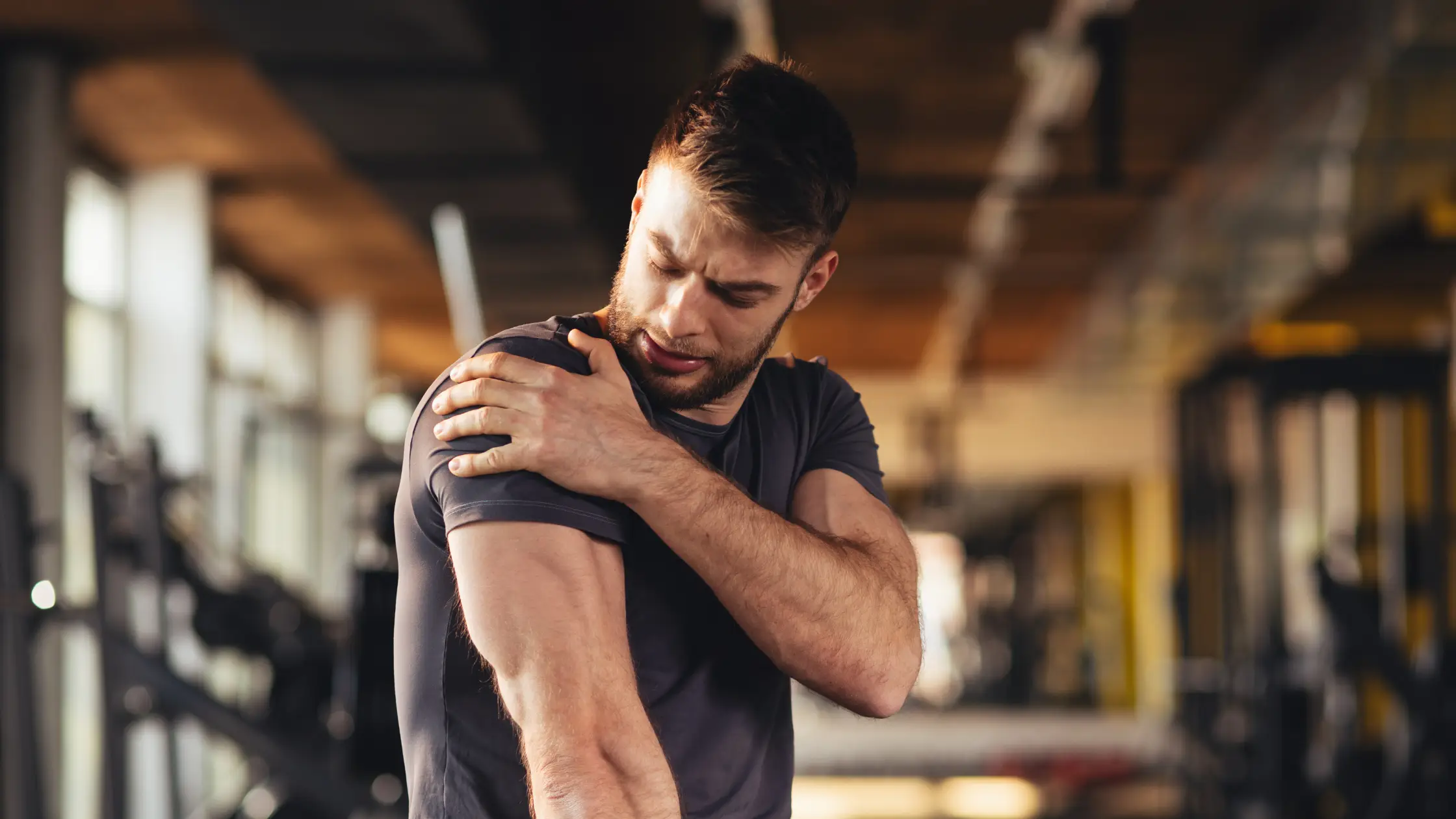 knee pain Man holding his shoulder in pain at the gym