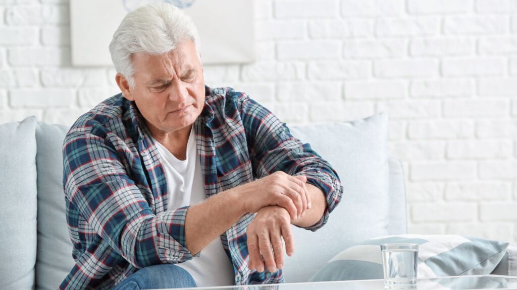 Older man rubbing his wrist