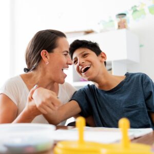 Mother drawing with son who has cerebral palsy